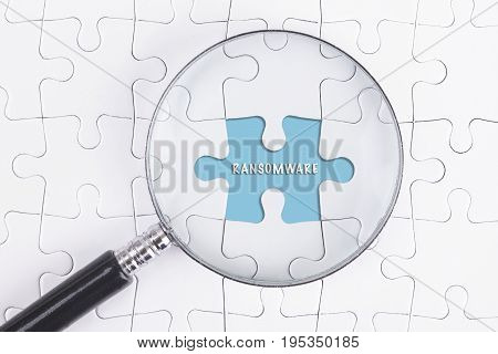 Business Concept - Magnifier Glass On White Puzze With Ransomware Word.