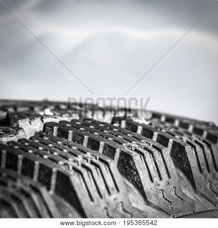 Tread winter car tire with spikes close-up.