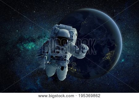 A depiction of an astronaut floating in outer space. An Earth-like planet sees sunrise in the background. Elements of this Image Furnished by NASA.