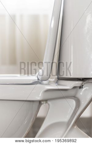 Part of white ceramic toilet bowl close-up.