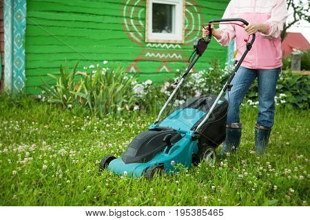 Closeup of grassmower moving on the grass