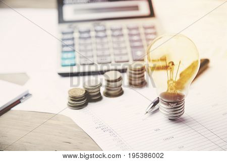 moneycalculator and light bulb on the financial papers