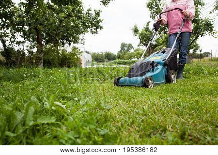 Closeup of grassmower moving on the grass