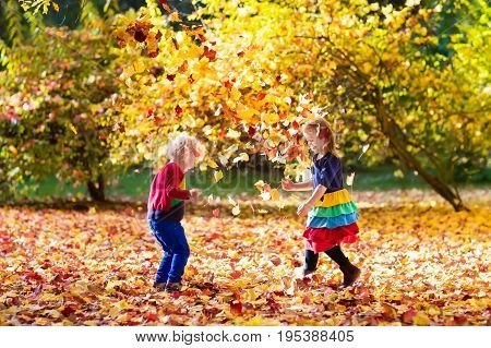 Kids Play In Autumn Park. Children In Fall.