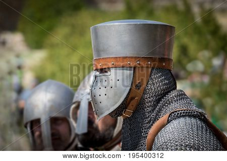 Medieval knight Isolated portrait with blurred background, reenactment with costumed characters and medieval armor with chainmail, helmet swords and shields. Medieval demonstration and recreation