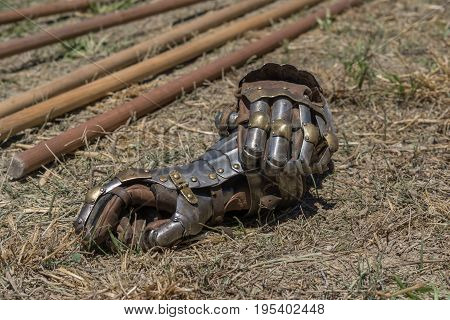 Detail of gloves as part of a metallic armor, on a reenactment with costumed characters and medieval armor with chainmail, helmet swords and shields. Medieval demonstration and recreation