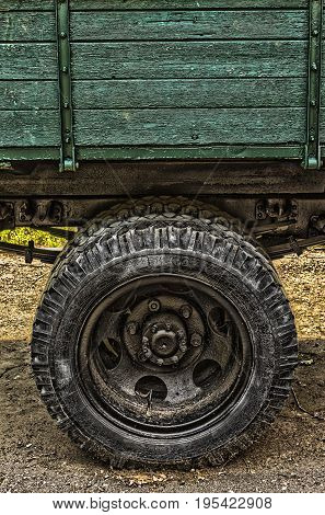 Retro lorry truck. Green color down side. Body silver exhaust pipe car wheel asphalt background. Macro view. soft focus.