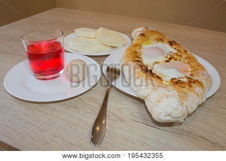 Adjarian khachapuri close-up. This traditional georgian dish contains brinsen cheese butter and row egg. Delicious homemade khachapuri in Adjarian