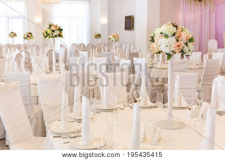 Restaurant interior for banquet, wedding decor. Glass, napkins and cutlery. Table appointments, laying.