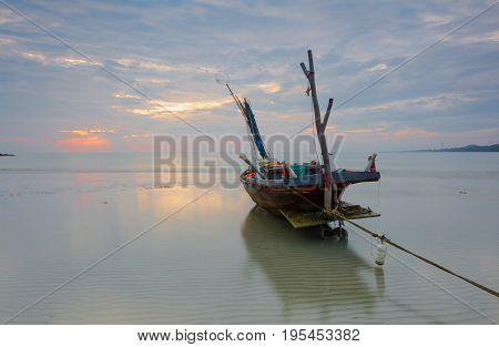 Fishing boat moored at sea after sunset near sunset.