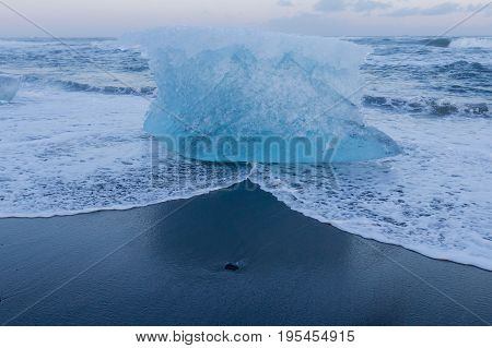 Ice breaking from glacier on black sand beach Iceland winter season landscape background