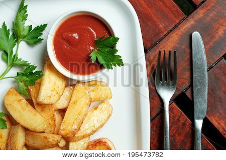Vegetarian dinner. Fried tofu with spices, potatoes with fresh tomatoes. On a white plate, wooden background