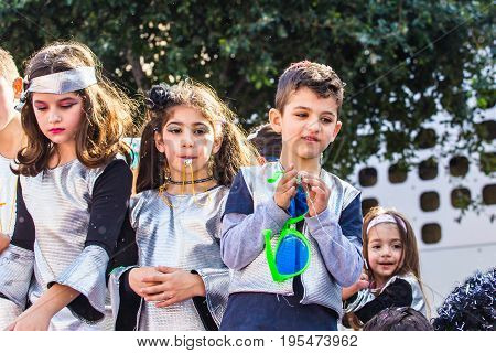 LIMASSOL, CYPRUS - FEBRUARY 26: Carnivalists in a silver cylinder hats joyfully follow the Limassol Municipality Band during the annual Carnival Parade, February 26, 2017 in Limassol.