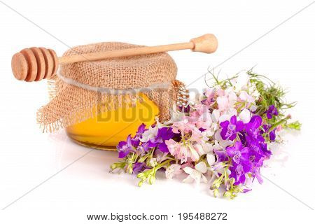 Jar of honey with wildflowers isolated on white background.
