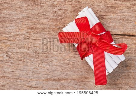 Cigarettes with red ribbon and bow. White tobacco cigarettes with big red bow and copy space.