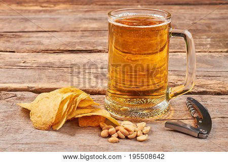 Glass of beer, chips, nuts, corkscrew. Concept of beer addiction.