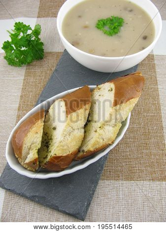 Lye baguette with herb butter and porcini mushroom cream soup