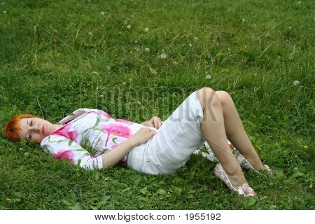 Sad Red-Haired Girl On A Grass