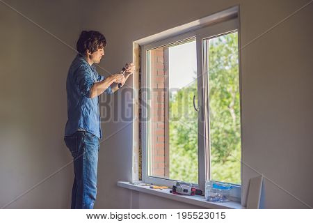 Man In A Blue Shirt Does Window Installation
