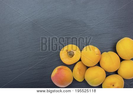 Ripe apricot on black background of slate or stone. Free space for text