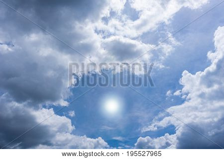 View on beautiful white Clouds on a blue Sky. Close-up of a cloudy Sky in the Morning. The Sun is shining from a blue Sky.