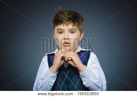 Closeup Scared and shocked little boys. Studio shot portrait over gray background. Human emotion face expression. Life perception achievement vision.