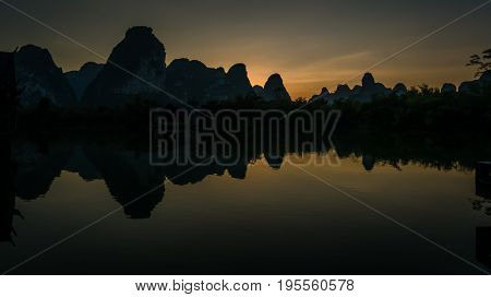 Sunset behind the south chinese mountains reflecting in a lake