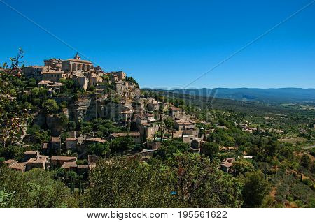 Panoramic view of the village of Gordes on top of a hill and under sunny blue sky. Located in the Vaucluse department, Provence region, in southeastern France.