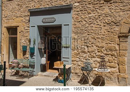 Lourmarin, France - July 07, 2016. Close-up of typical stone houses and shops on a street of the historical village of Lourmarin. Located in Vaucluse department, Provence region, southeastern France