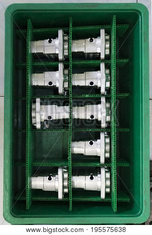 Automotive Aluminium parts kept in a green plateic box ; parts produced by Low Pressure Die casting process and high accuracy cnc machining machine
