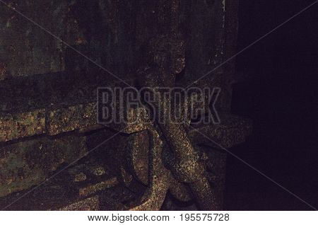 Old terrible rusty door from the bomb shelter in a completely dark dungeon. Vintage action.