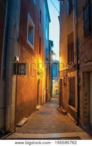 Rians, France - July 08, 2016. View of narrow alley in the early evening with lamp lit, in the lovely village of Rians. Located in Var department, Provence region, in southeastern France.