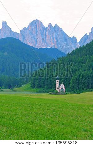 San Giovanni Church in front of dolomites mountain peaks in Santa Magdalena Italy