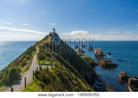 Lighthouse on Nugget Point. It is located in the Catlins area on the Southern Coast of New Zealand, Otago region. The Lighthouse is surrounded by small rock islands, nuggets