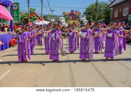 CHIANGMAI THAILAND - JANUARY 25 2015: Indigenous women with traditional purple costume dancing in traditional style in parade of 22nd Traditional Skirt Fabric and The Indigenous Product and Culture Festival in Mae Chaem Chiangmai Thailand