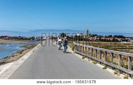 two women cycling on the Jacobsen Jetty on the island of Noirmoutier (France)