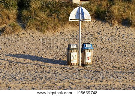 DE PANNE BELGIUM - JULY 02 2017:Two garbage bin for recycling on sand at the beach of De Panne in Belgium