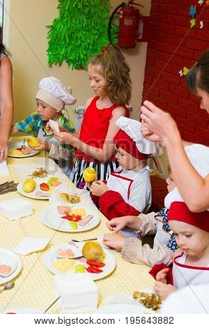 Alchevsk, Ukraine - July 16, 2017: Children's Master Class On Cooking Potatoes In The Oven With Ham 