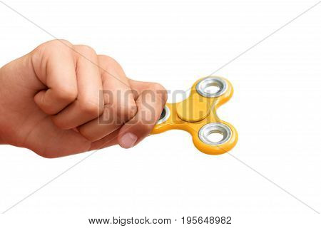 Yellow hand spinner. Boy playing a popular toy fidget spinner in his hand. Stress relief. Anti stress and relaxation adhd attention fad boy concept