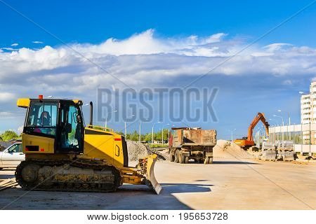 Crawler tractor with bucket on construction of high-speed ring road around Krasnoe Selo Saint Petersburg. Heavy machine equipment for excavation works at civil industrial construction. Russia