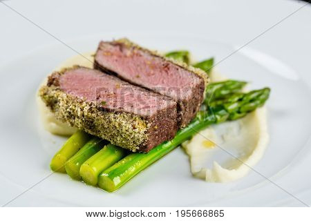 medium done grilled tuna steak with asparagus served on the asparagus and mashpotato