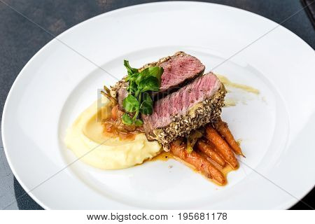 medium done grilled tuna steak in batter served with the baby carrot and mashpotato
