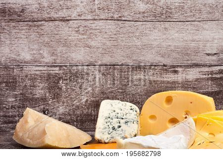 Different type of cheese on wooden background. Gourmet food apetizer