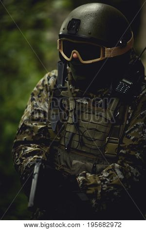 Strikeball player in camouflage with submachine gun in reconnaissance