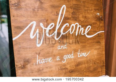 wooden tablet with inscriptions welcome and have a good time