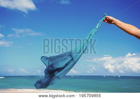 blue pareo shawls flowing in the wind on background of sea