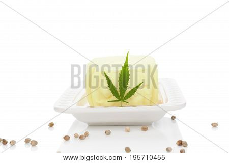 Ganja butter with leaf on white saucer isolated on white background. Hemp butter. Alternative remedy.