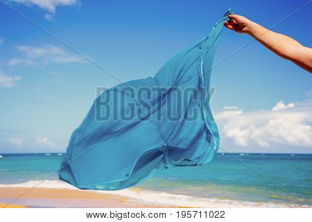 blue pareo shawls flowing in the wind on background of sea