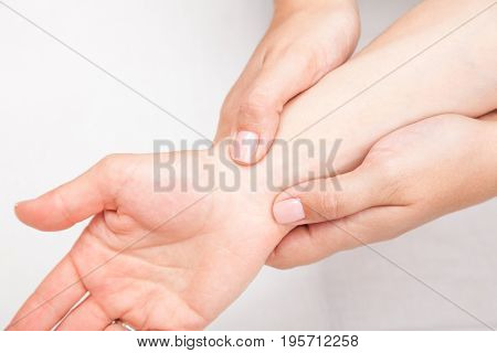 Young woman's wrist being manipulated by osteopathic manual therapist or physician