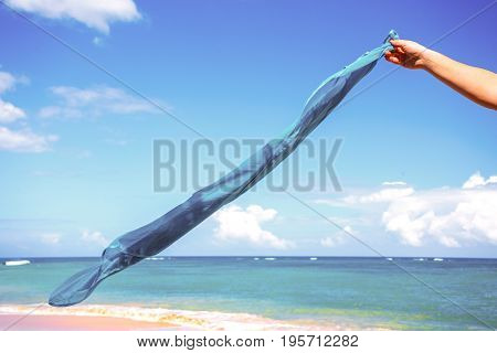 blue pareo shawls flowing in the wind on background of sea